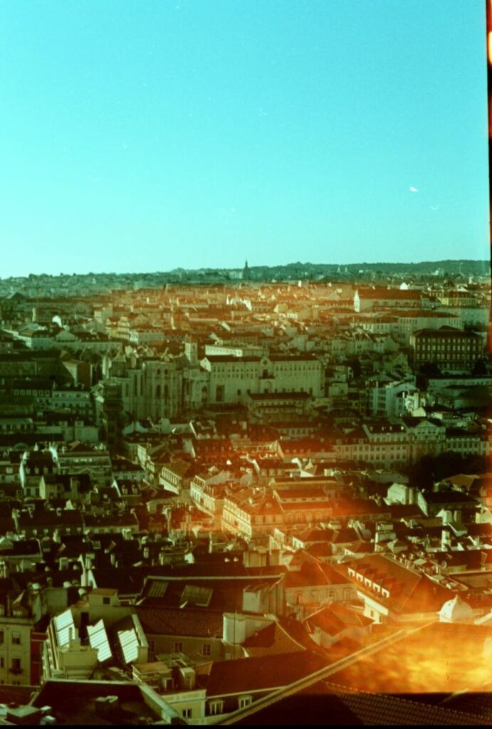 A 35mm film photo of Lisbon that got light leaked from airport X-ray scanners. 